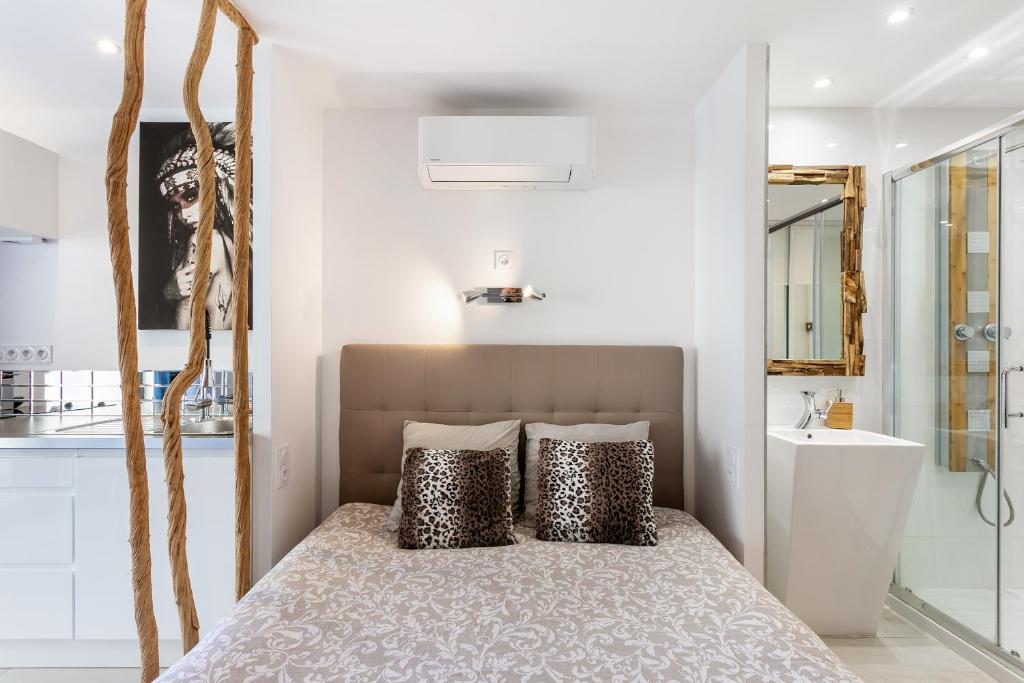 sypialnia z łóżkiem z poduszkami w obiekcie Java Heliopolis naturiste w Cap d'Agde