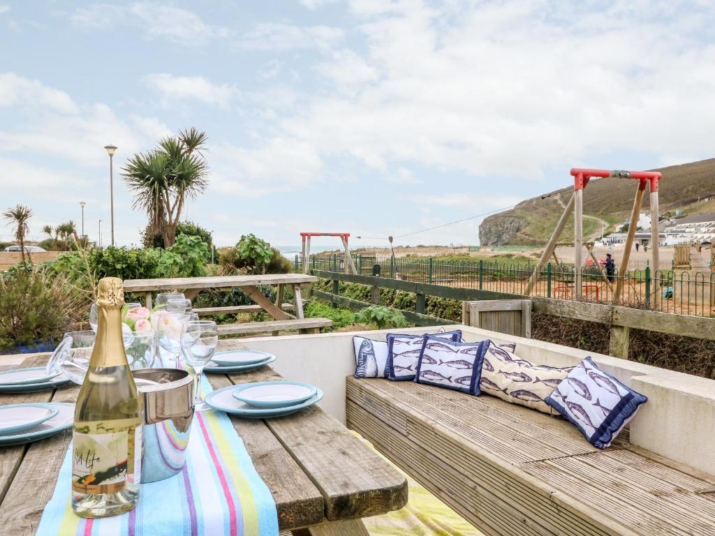 a picnic table with a bottle of wine and a playground at Offshore in Porthtowan