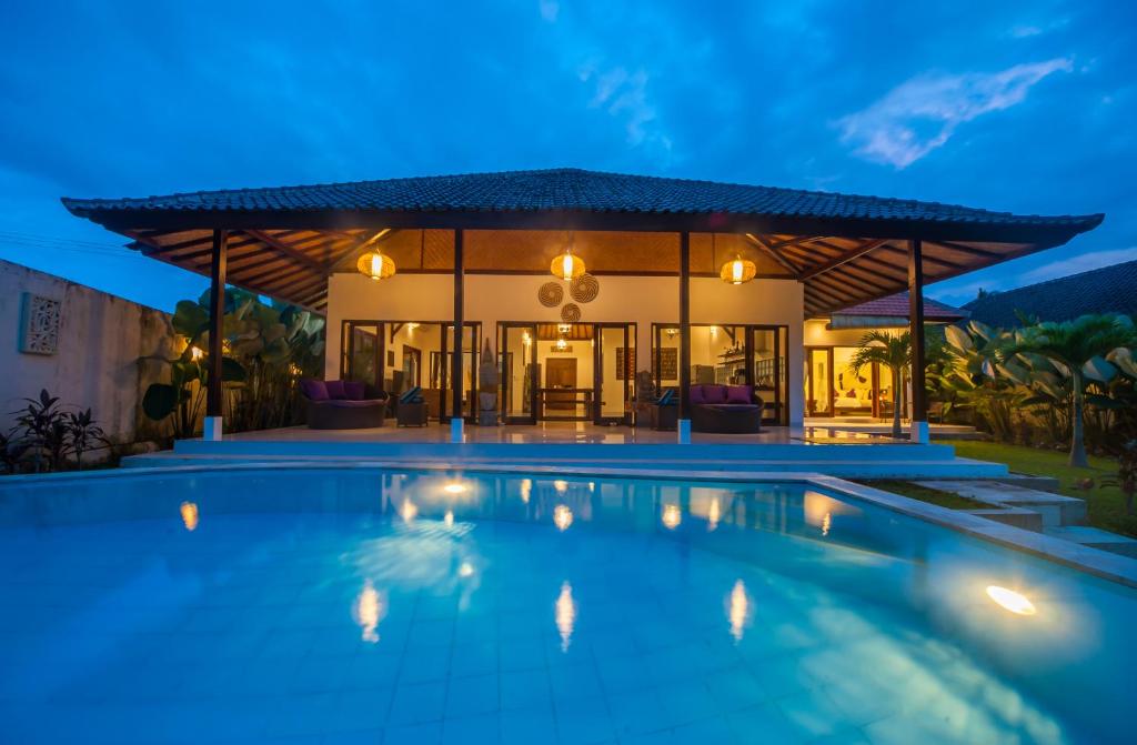 Villa con piscina por la noche en Axros Villa, en Ubud