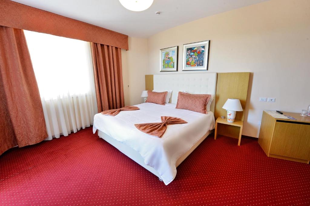 a hotel room with a large bed and a window at Jolly Hotel in Lezhë