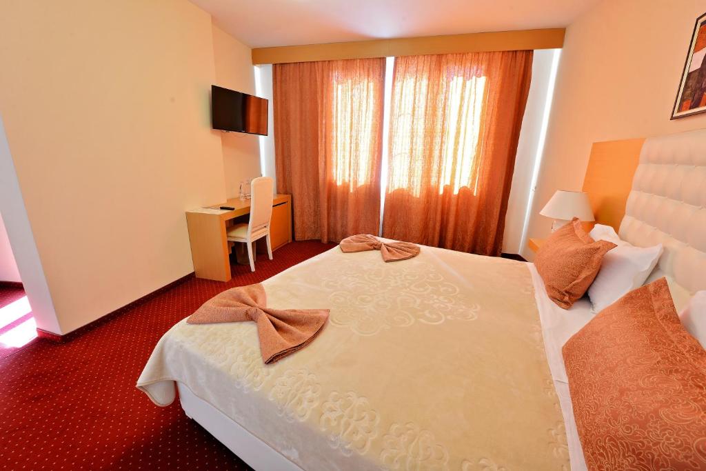 a hotel room with a bed and a desk at Jolly Hotel in Lezhë