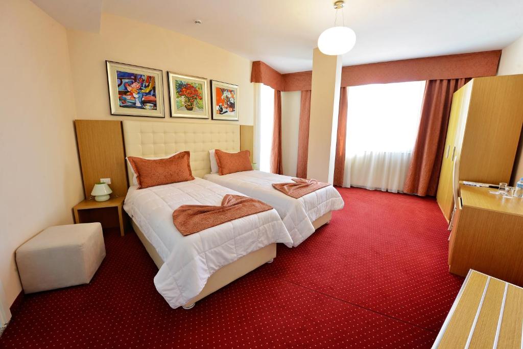 a hotel room with a bed and a red carpet at Jolly Hotel in Lezhë