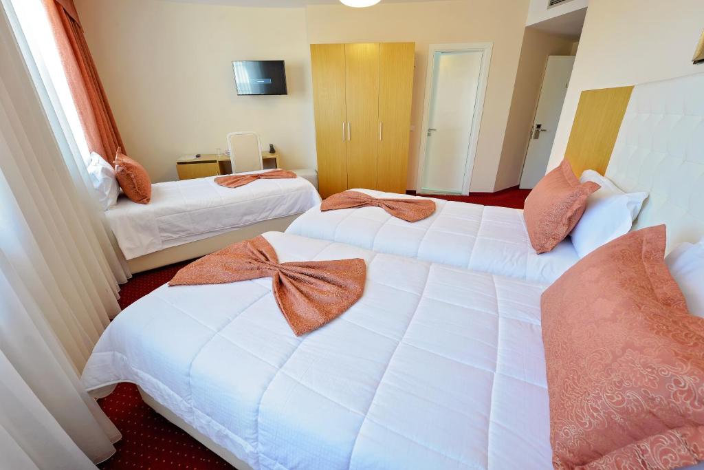 a hotel room with two beds with bows on them at Jolly Hotel in Lezhë