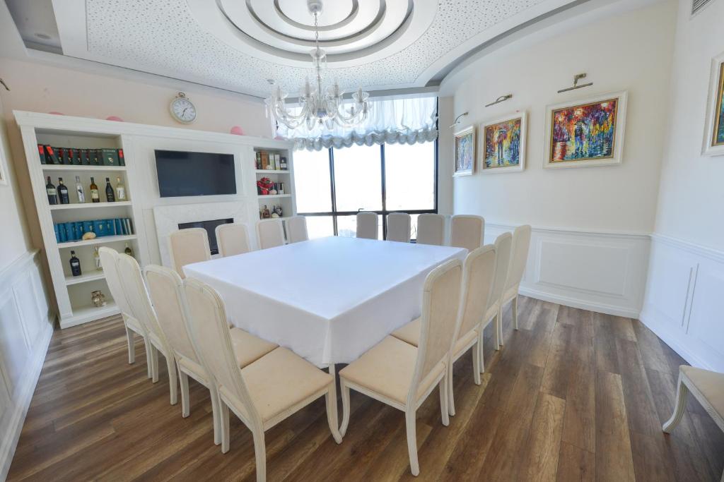 a dining room with a white table and chairs at Jolly Hotel in Lezhë