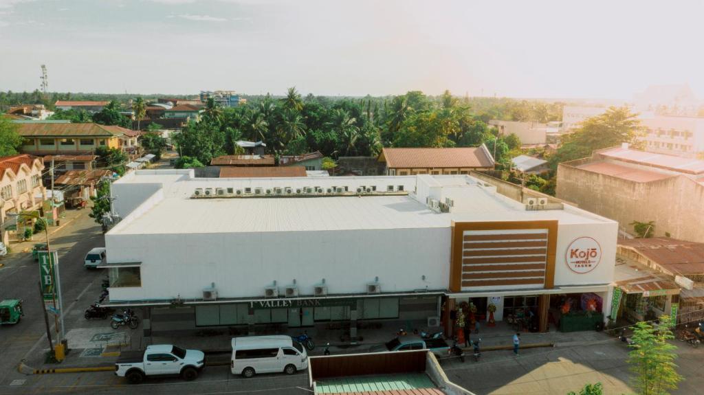 a white building on a city street with cars parked at Kojõ Hotel Tagum in Tagum