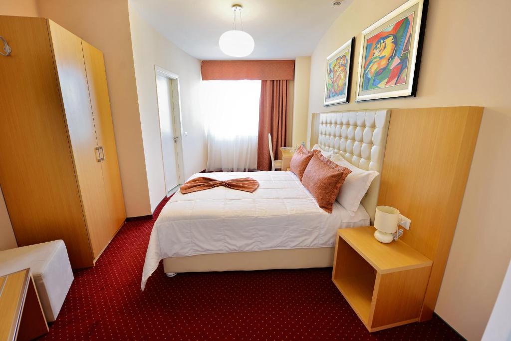 a hotel room with a bed and a window at Jolly Hotel in Lezhë
