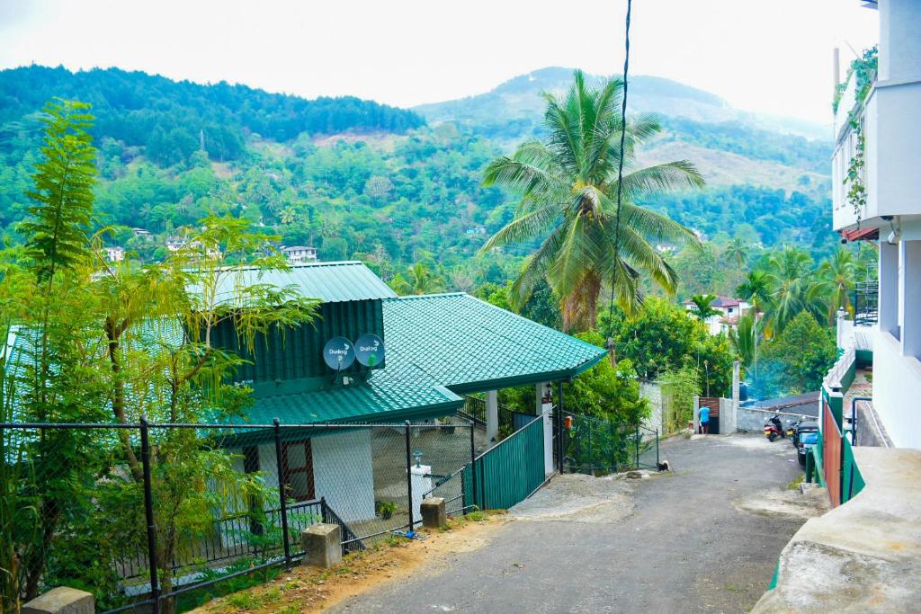 a house with a green roof on a street at RIVERVIEW Guest in Kandy