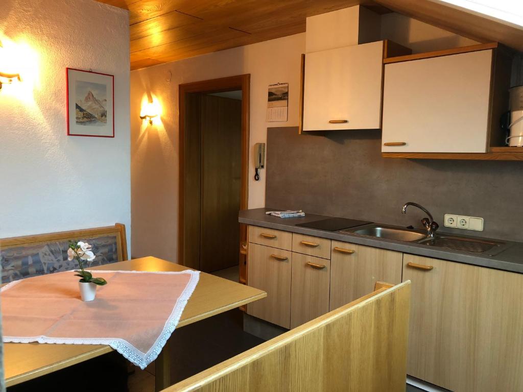 cocina con mesa, fregadero y encimera en Haus Kneissl, en Seefeld in Tirol