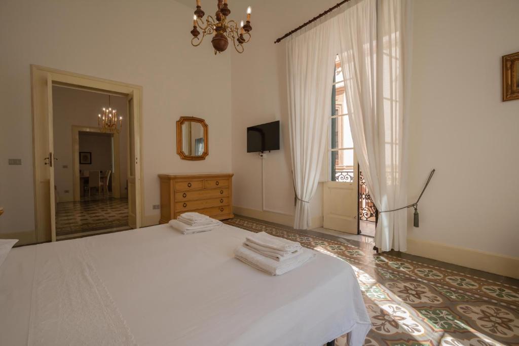 a bedroom with a white bed and a mirror at Dimora Apulia in Brindisi