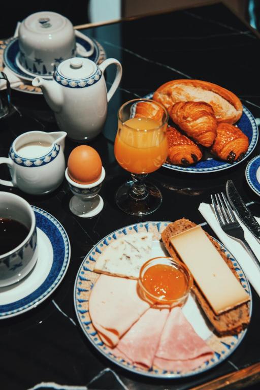 a table topped with plates of food and eggs and bread at Waldorf Montparnasse in Paris