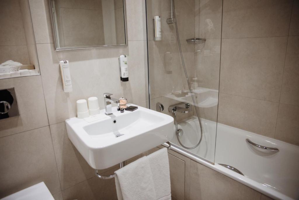 a bathroom with a sink and a shower at Waldorf Montparnasse in Paris