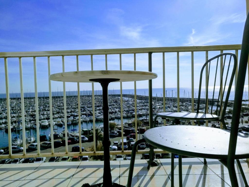 d'un balcon avec deux chaises et une vue sur le parking. dans l'établissement Les Aigues Marines - belle vue mer et port, à Palavas-les-Flots