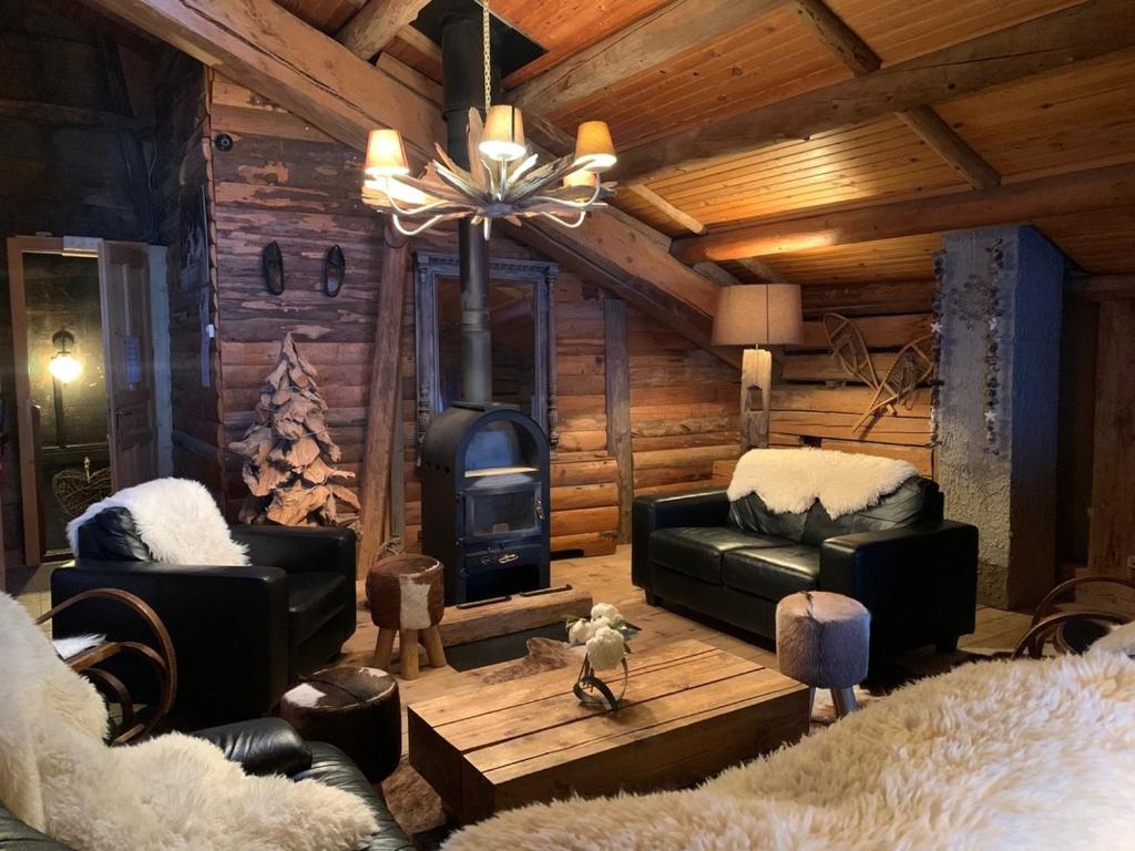 a living room with a fireplace in a log cabin at La Bournerie in Le Grand-Bornand