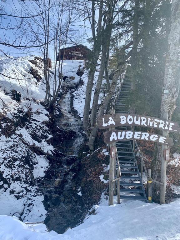 a sign in the snow next to a stream at La Bournerie in Le Grand-Bornand