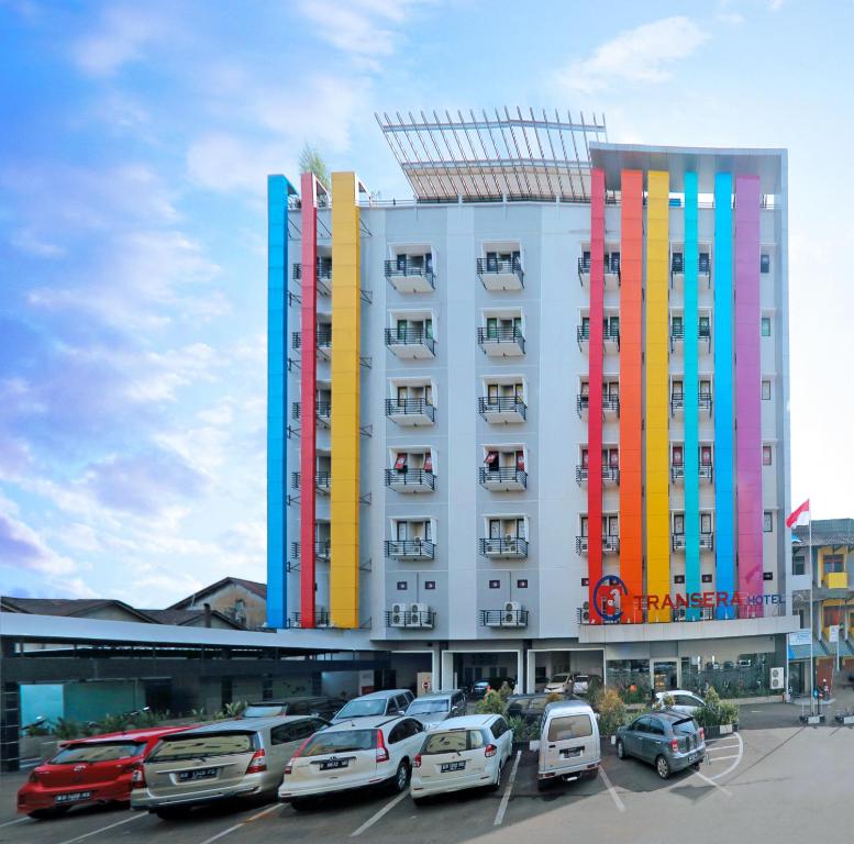 un gran edificio con coches estacionados en un estacionamiento en Transera Hotel Pontianak en Pontianak