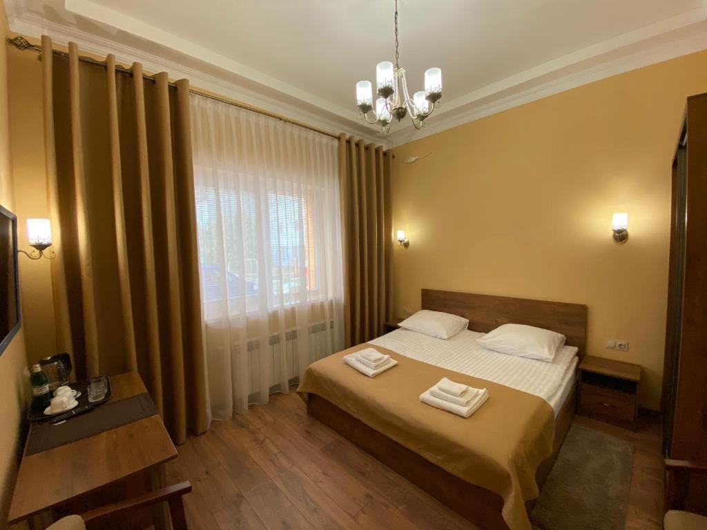 una camera da letto con un letto con due asciugamani sopra di Сонячна Соната a Polyana