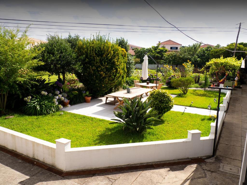 un jardín con mesa, bancos y plantas en Swara Slow Living Home, en Aveiro