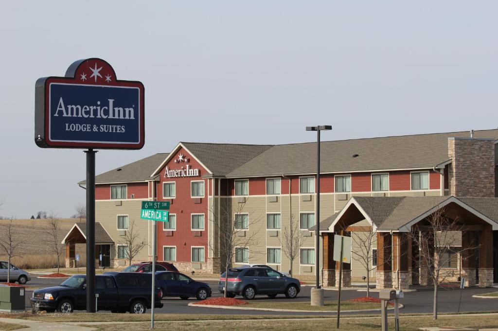 een bord voor een hotel met auto's geparkeerd op een parkeerplaats bij AmericInn by Wyndham Cedar Rapids Airport in Cedar Rapids