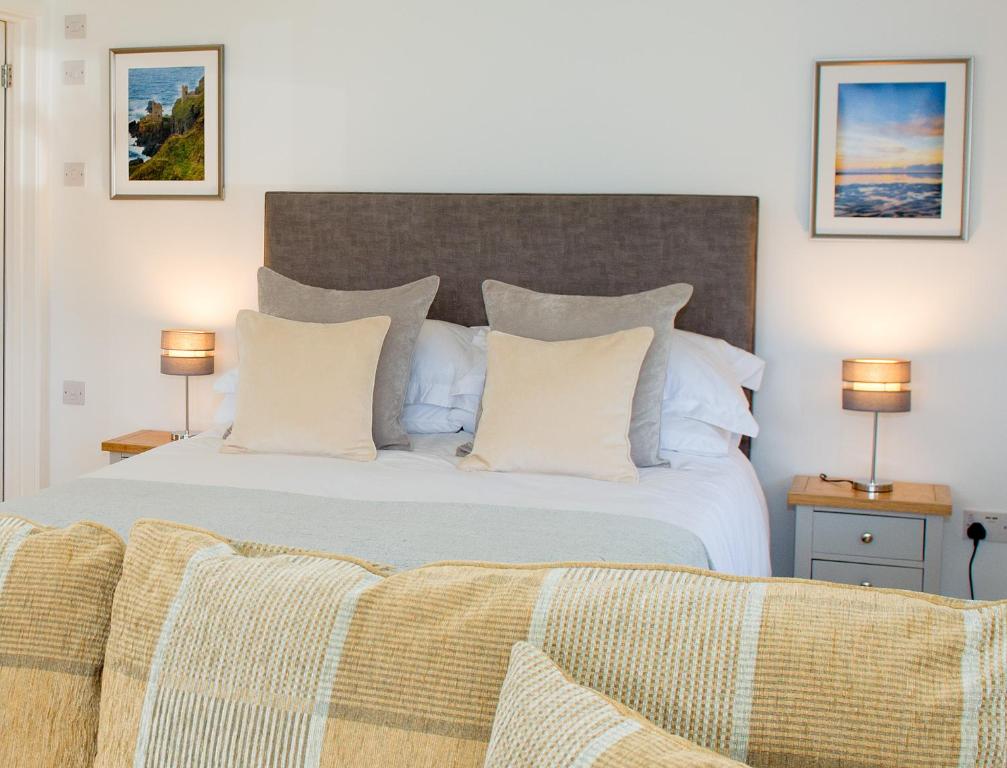 a bedroom with a large white bed with two lamps at Hillside Studio in Penzance