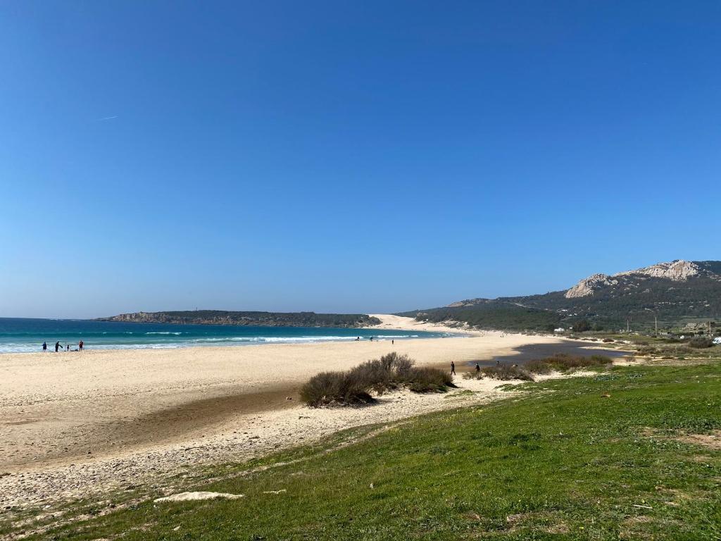 a beach with people on the sand and the ocean at La Casita de Laura in Bolonia