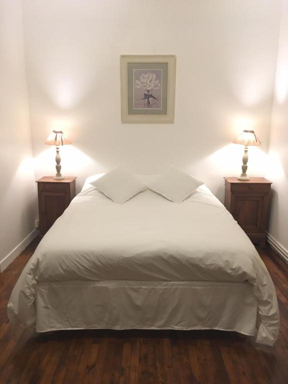 a bedroom with a white bed with two lamps at Les Terrasses d'Angoulême in Angoulême