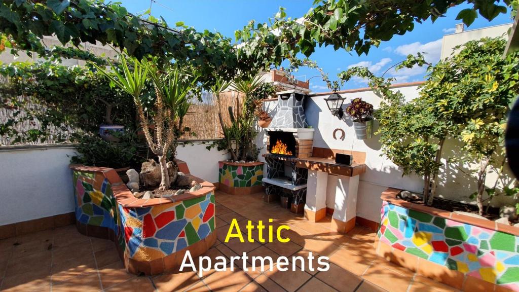 an outdoor patio with a fireplace and plants at Airport BCN, Atico terraza & BBQ, Puerto Cruceros a 15 minutos in Viladecáns