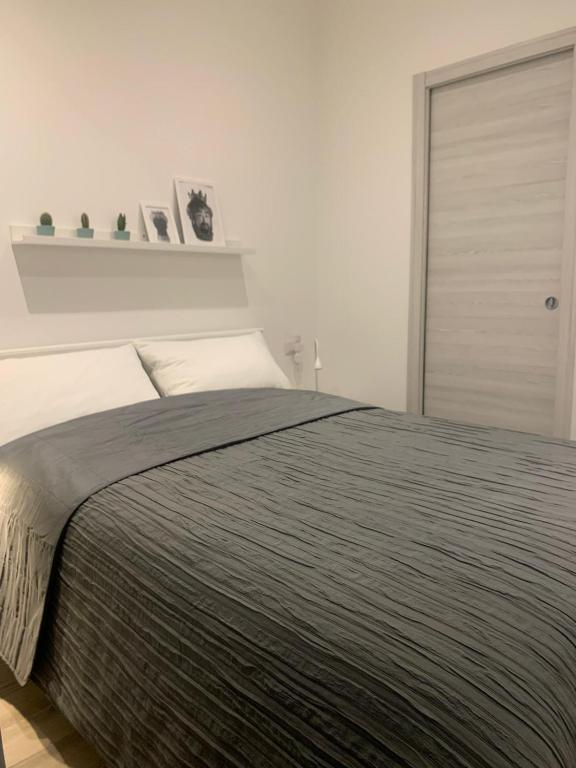 sypialnia z dużym łóżkiem i szarym kocem w obiekcie CATANIA CENTRAL DELUXE HOUSE w Katanii