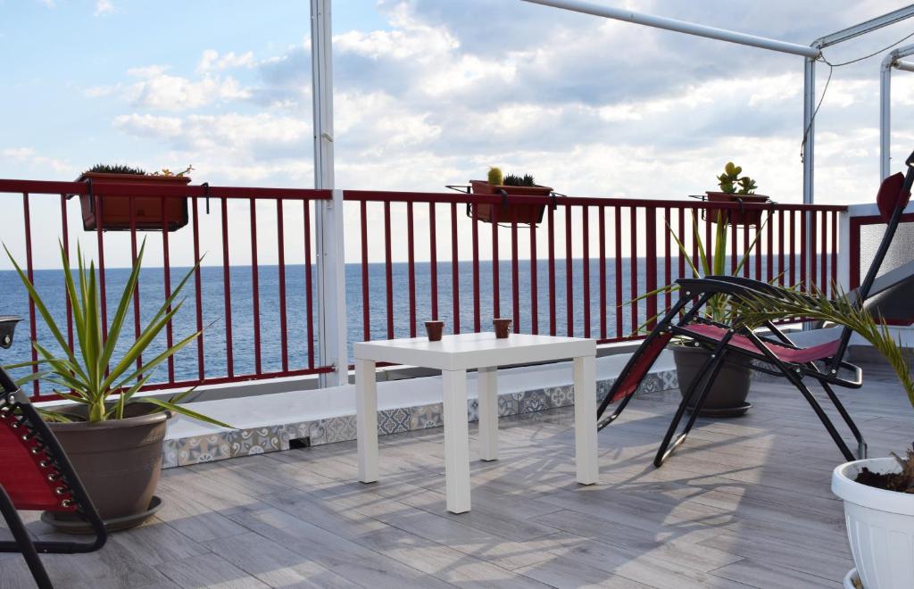 balcón con mesa blanca y vistas al océano en Ionio Sea Apartment, en Marina di Gioiosa Ionica