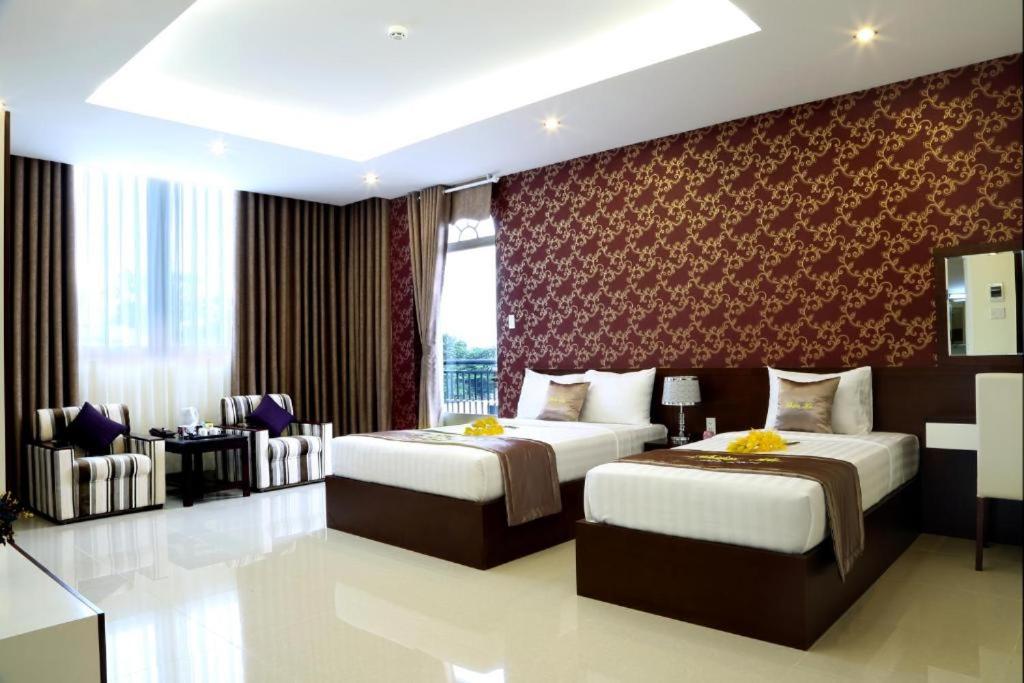 Habitación de hotel con 2 camas y sofá en Thien Ha Hotel & Apartment, en Ho Chi Minh