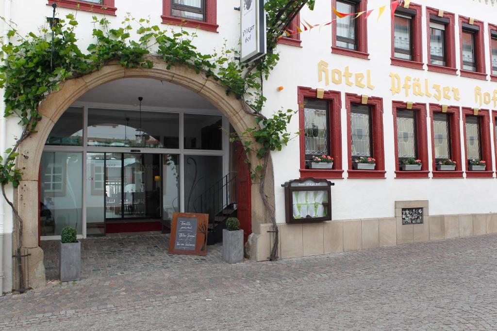 ein Gebäude mit einem Torbogen vor einem Geschäft in der Unterkunft Hotel-Restaurant Pfälzer Hof in Edenkoben