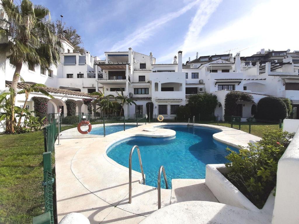 a swimming pool in front of a building at Elegant apartment in Puerto Banus in Marbella