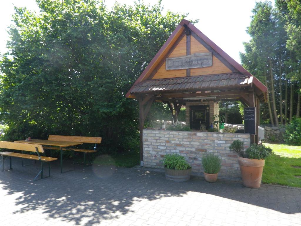 einen Pavillon mit einem Picknicktisch und einer Bank in der Unterkunft Alte Malztenne im Herzen der Schorfheide in Golzow