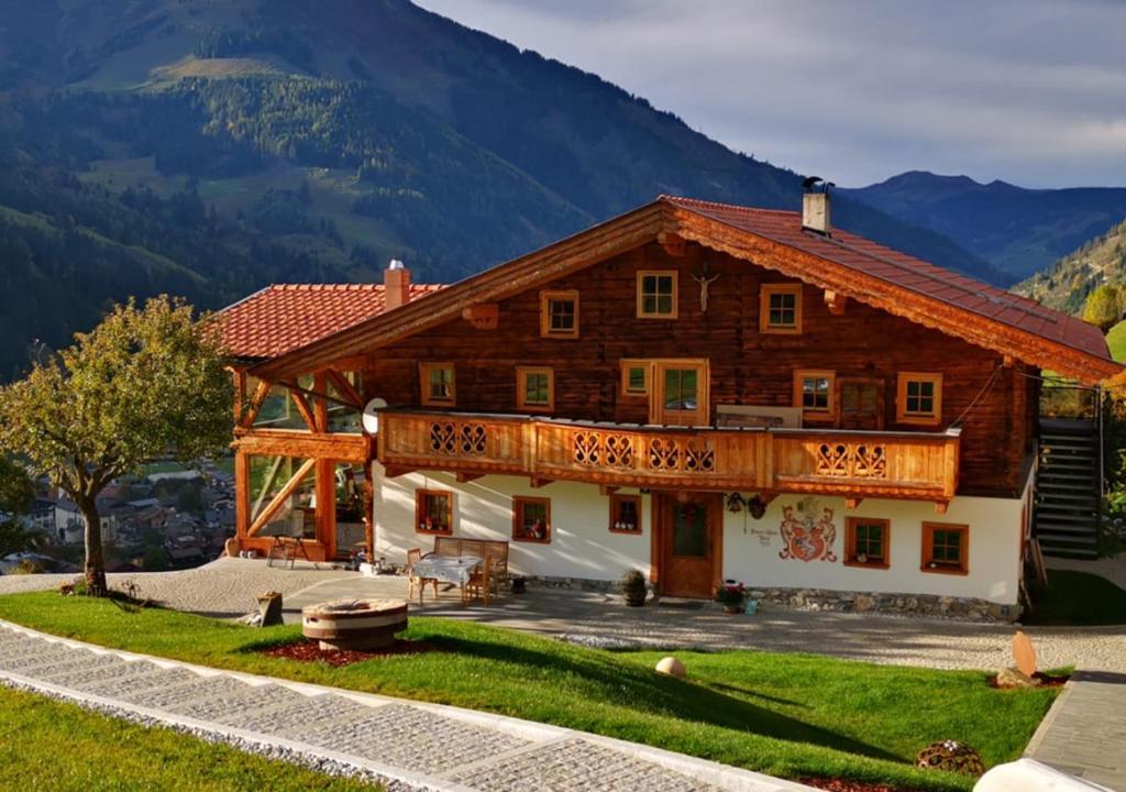 a large wooden house with mountains in the background at Langrieshof in Rauris