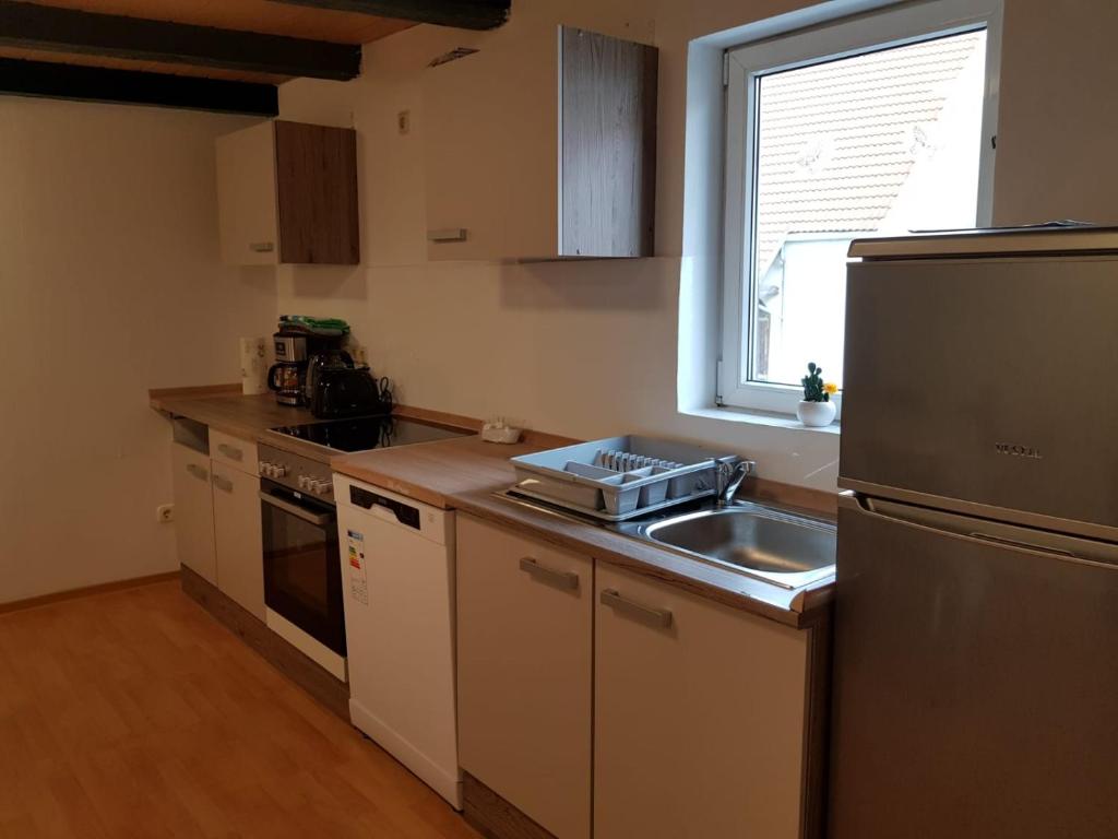 a small kitchen with a sink and a refrigerator at LMI Haus & Urlaub Monteurwohnungen 2 in Münsingen