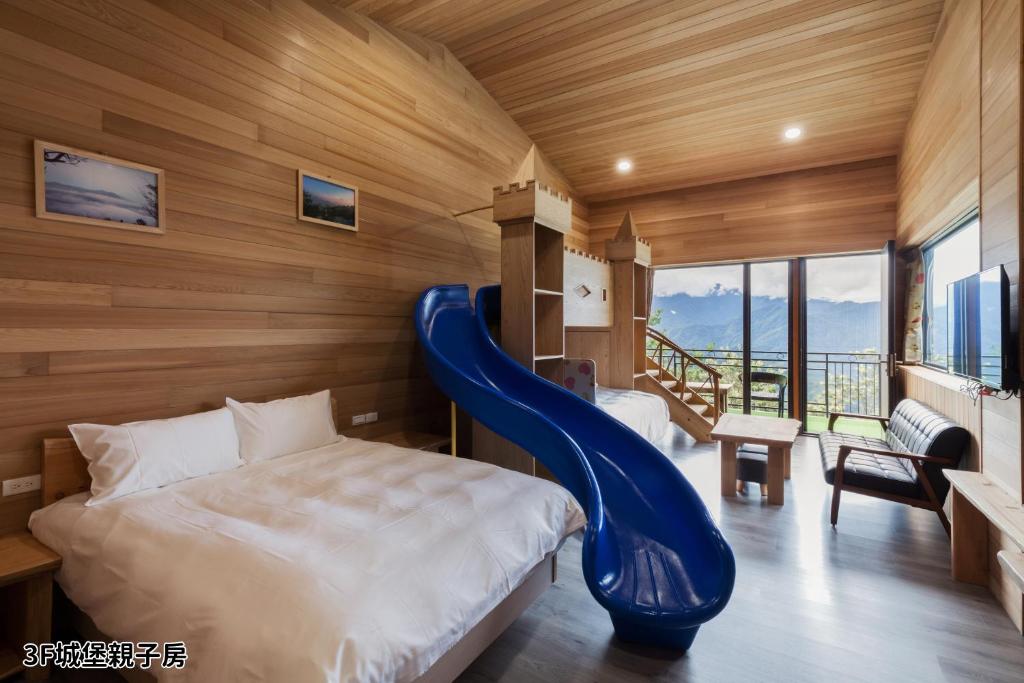 a bedroom with a bed with a blue slide at Chingjing Abin Minshuku in Renai
