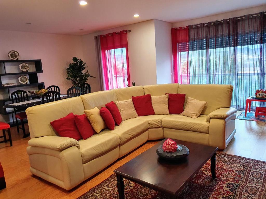 Apartamento T3-S.PedroII في بونتا ديلغادا: غرفة معيشة مع أريكة عليها وسائد حمراء