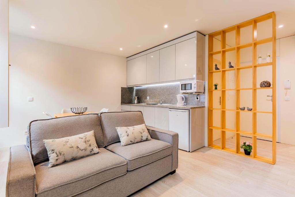 een woonkamer met een bank en een keuken bij Lemago Porto Apartments - São Bento in Porto