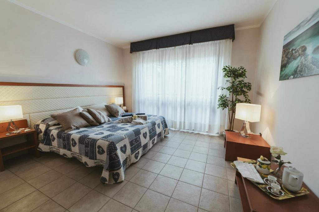 1 dormitorio con cama y ventana grande en Beverly Park Residence, en Tirrenia