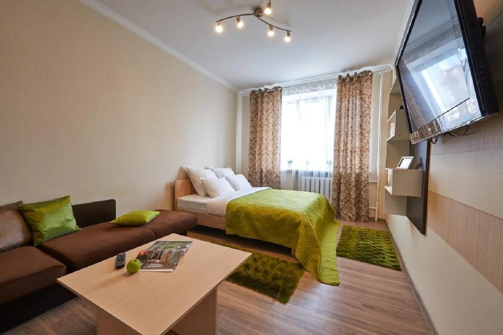 a small living room with a bed and a couch at PaulMarie Apartments on Mira 25B in Mogilev