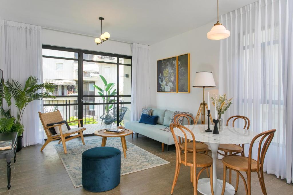 - un salon avec une table, des chaises et un canapé dans l'établissement Mr. Brooklyn - By TLV2GO, à Tel Aviv