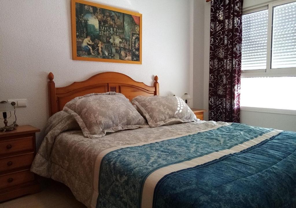 ein Schlafzimmer mit großem Bett und Fenster in der Unterkunft Precioso piso en Roquetas de Mar in Roquetas de Mar