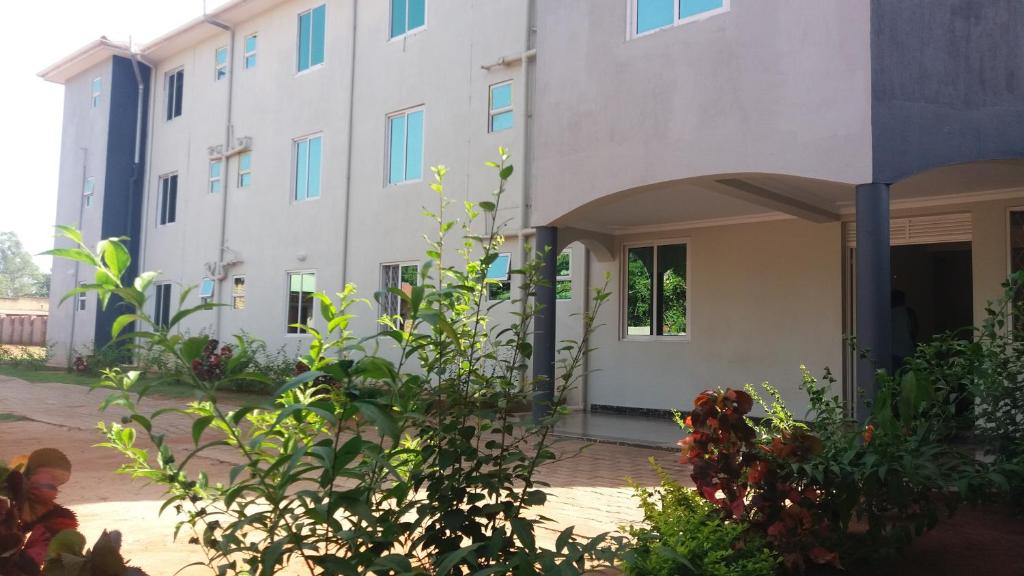 une vue extérieure d'un bâtiment avec des plantes dans l'établissement Dich Comfort Hotel University Branch, à Gulu