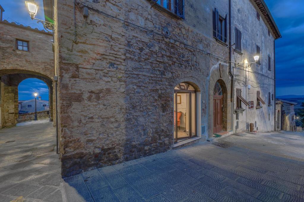 a stone building with arches on a street at La Rocca in Gambassi Terme