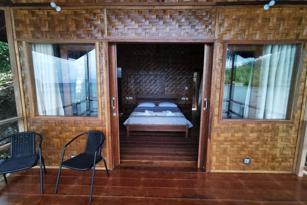 Zimmer mit einem Bett und zwei Stühlen auf einer Veranda in der Unterkunft SeaGate Bungalows in Sabang