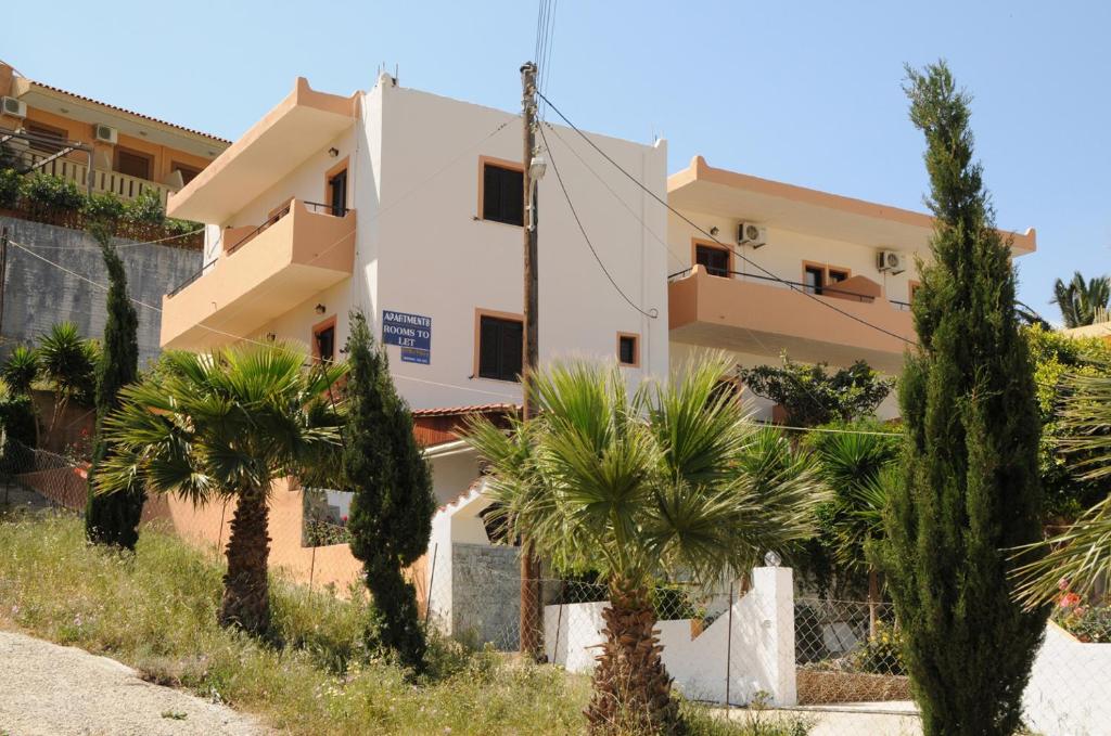 dom z palmami przed nim w obiekcie Villa Dora w mieście Plakias