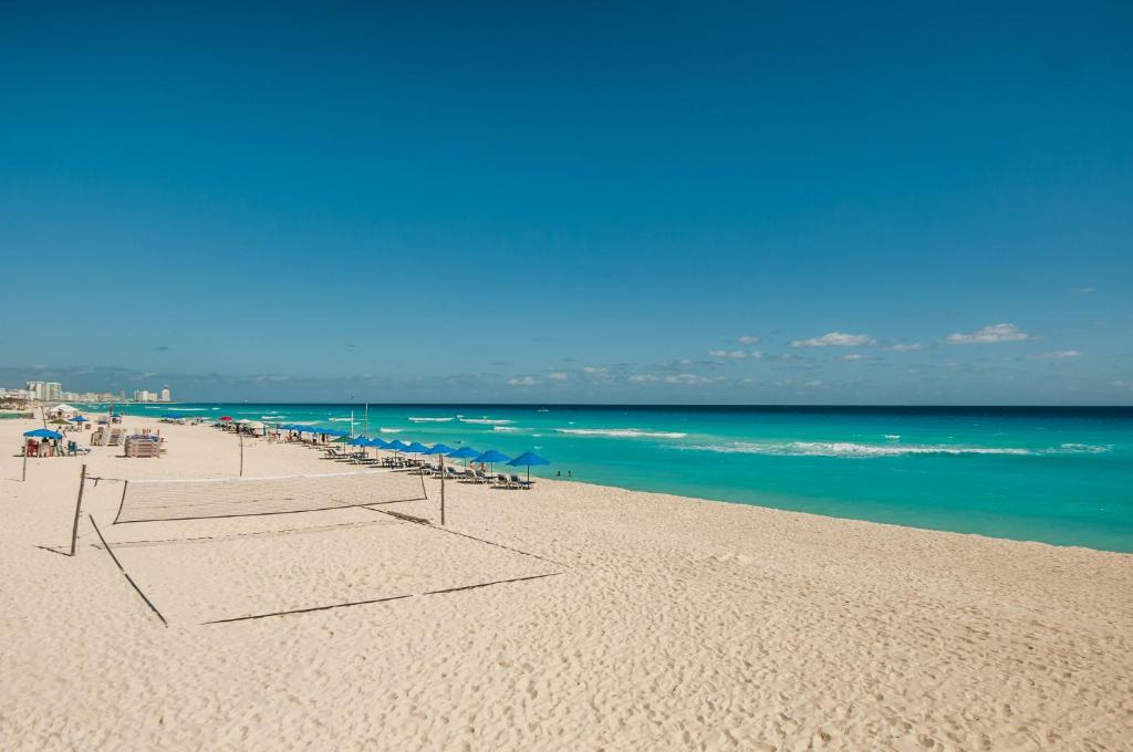 a beach with a row of umbrellas and the ocean at HotelZone L16 Beach Access in Cancún