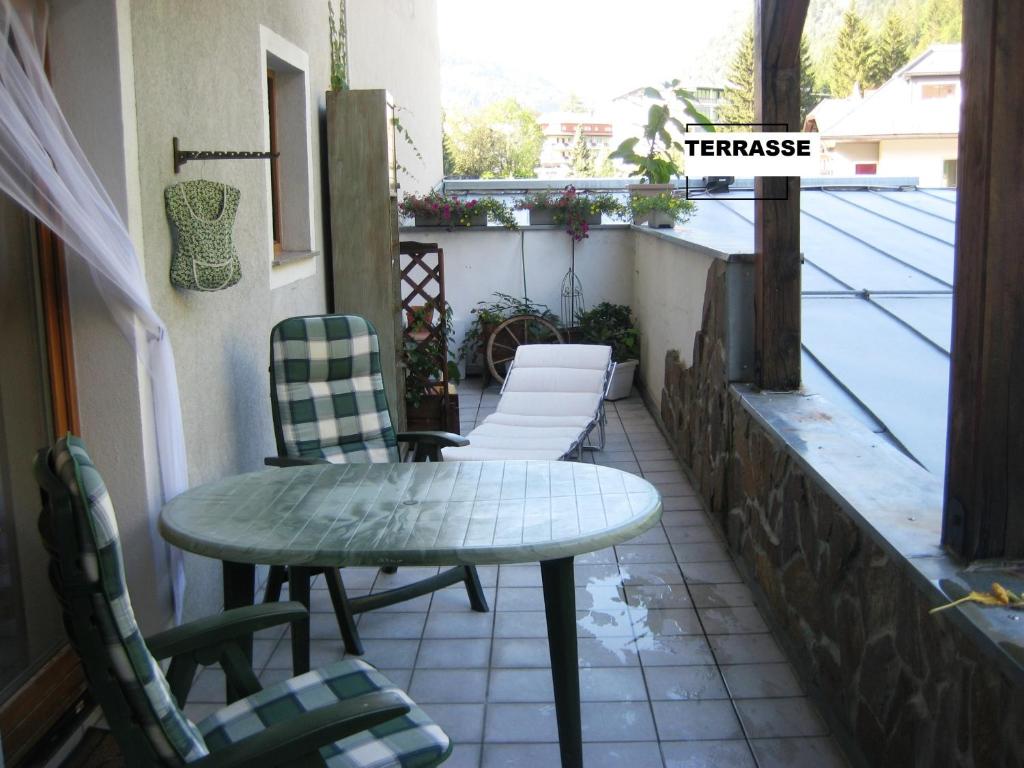 a patio with a table and chairs on a balcony at Privat Apartment in Bad Hofgastein