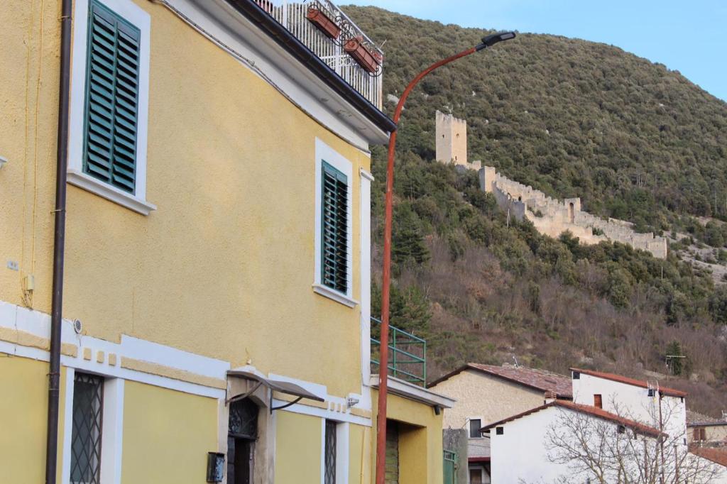 een gebouw met een straatlicht voor een berg bij A due passi dal castello in San Pio delle Camere