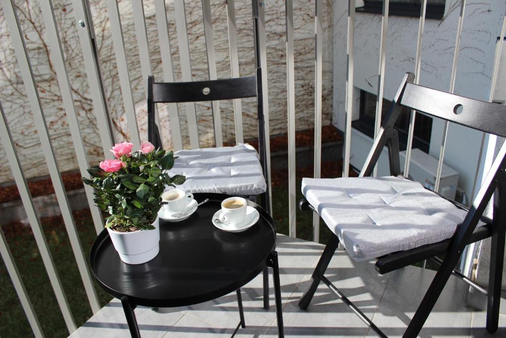 a black table with flowers and two chairs on a balcony at LEO Apartment FREE PARKING!!! in Bratislava
