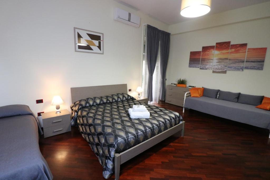 um quarto com uma cama e um sofá em Il Fuso em Salerno